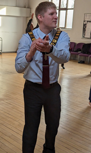 A photograph of Neil Darby dancing with DanceSyndrome in a community centre