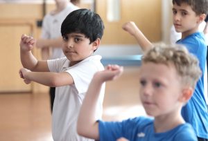 Children taking part in a DanceSyndrome inclusive dance session in a school setting.